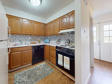 Ballwin townhouse for rent - a kitchen with black appliances and wooden cabinets