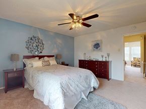 Ballwin townhouse for rent - a bedroom with a bed and a ceiling fan