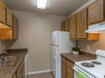 Rapid City apartment for rent - A kitchen with a white refrigerator and stove top oven.