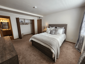 Fitchburg apartment for rent - A bedroom with a large bed and a wooden headboard.