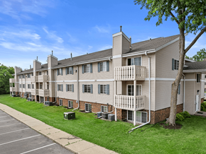 Fitchburg apartment for rent - an image of an apartment building with green grass and trees at sun valley apartments