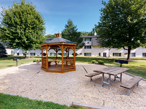 Erie townhouse for rent - A gazebo is in the middle of a gravel area with a picnic table and benches.
