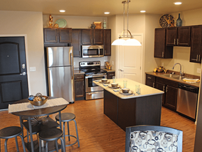 Minot apartment for rent - apartment kitchen with stainless steel appliances and a large island with a breakfast bar