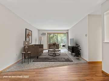 Maumee apartment for rent - A living room with a brown couch and a rug.