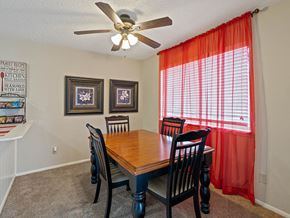 Kansas City triplex for rent - a dining room with a table and chairs and a ceiling fan