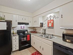 Kansas City triplex for rent - a kitchen with black appliances and white cabinets