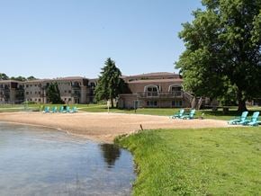 Grand Rapids apartment for rent - a beach with chairs and a body of water in front of a building
