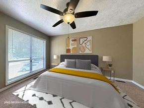 Fayetteville apartment for rent - A bedroom with a large bed and a ceiling fan.