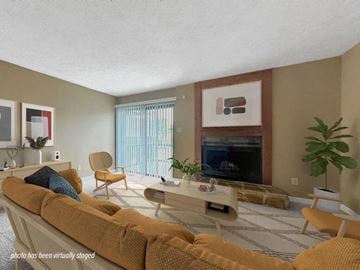 Fayetteville apartment for rent - A living room with a yellow couch and a fireplace.