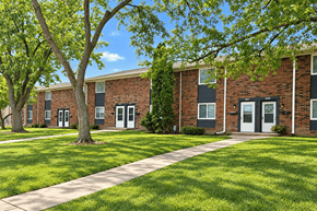 Decatur apartment for rent - A tree in front of a brick building with a walkway in between.
