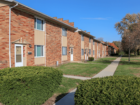 Decatur apartment for rent - A row of red brick apartment buildings with green bushes in front.