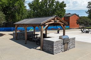 Cedar Rapids apartment for rent - A picnic pavilion with a grill is situated in a concrete lot.
