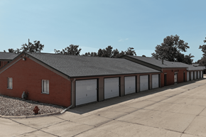 Cedar Rapids apartment for rent - A red brick building with a grey roof and white garage doors.