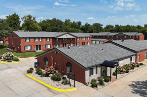 Cedar Rapids apartment for rent - A large red brick building with a parking lot in front.