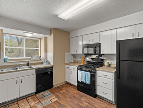 Kansas City apartment for rent - a kitchen with black appliances and white cabinets