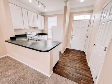 Reynoldsburg apartment for rent - a kitchen with white cabinets and a sink and a refrigerator