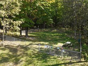 Marquette apartment for rent - A fenced-in area with a picnic table in the middle of a grassy field.