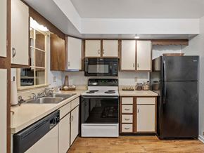Muskegon apartment for rent - a kitchen with a stove top oven next to a refrigerator