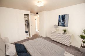 Sioux City apartment for rent - a bedroom with a bed and a dresser with a lamp