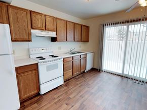 Rochester townhouse for rent - A kitchen with wooden cabinets and white appliances.