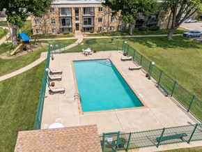 Rochester townhouse for rent - A green fenced in pool with a building in the background.