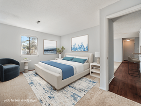 Fayetteville apartment for rent - A bedroom with a large bed and a blue and white rug.