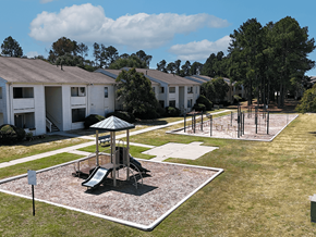 Columbia apartment for rent - A playground area with a slide and a swing set in the middle of a grassy area.