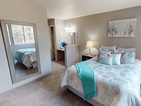 Albuquerque apartment for rent - A bedroom with a large bed and a mirror on the wall.