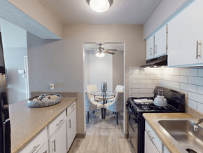 Albuquerque apartment for rent - A kitchen with a black stove top oven and a white refrigerator.