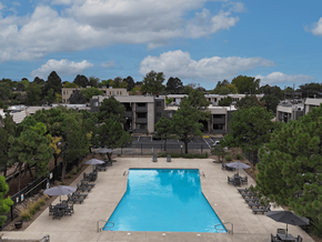 Albuquerque apartment for rent - A large swimming pool surrounded by lounge chairs and umbrellas.