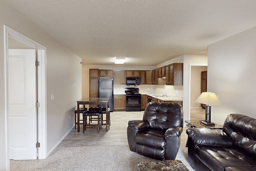 Williston apartment for rent - A living room with a black leather couch and chair.