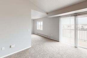 Williston apartment for rent - A spacious room with a sliding glass door leading to a balcony.
