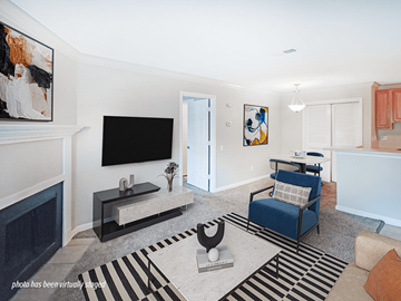 Little Rock apartment for rent - A living room with a blue chair and a television.