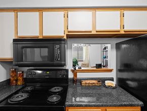 Topeka apartment for rent - a kitchen with a black stove and a microwave