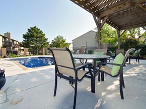 Wichita apartment for rent - a patio with a table and chairs next to a pool