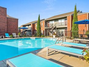 Topeka apartment for rent - a large swimming pool with some chairs around it