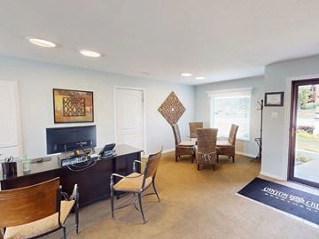 Mehlville townhouse for rent - a living room with a desk and chairs and a television
