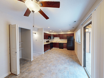 Mehlville townhouse for rent - A kitchen with a refrigerator, sink, and cabinets is visible from the living room.