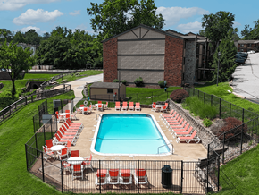 Mehlville townhouse for rent - A pool surrounded by red chairs and a black fence.