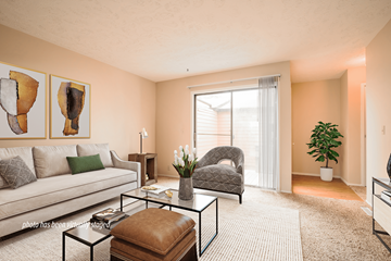 Omaha triplex for rent - A living room with a couch, chair, and two paintings on the wall.