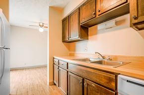 Omaha triplex for rent - A kitchen with wooden cabinets and a white refrigerator.