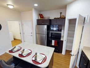 Minot apartment for rent - a kitchen with a table and chairs and a stainless steel refrigerator