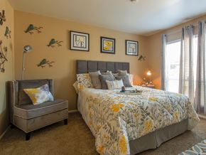Maryland Heights townhouse for rent - A bedroom with a large bed and a bench.