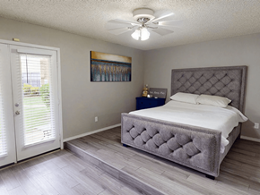 Abilene apartment for rent - A bedroom with a large bed and a painting on the wall.