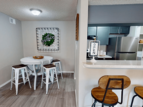 Abilene apartment for rent - A kitchen with a table and chairs in the foreground and a kitchen in the background.