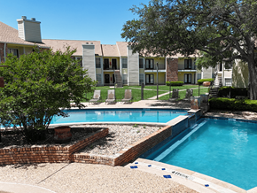 Abilene apartment for rent - A pool surrounded by a brick wall and a tree.