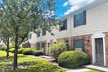 New Bern apartment for rent - A tree is in front of a white building with a black door.