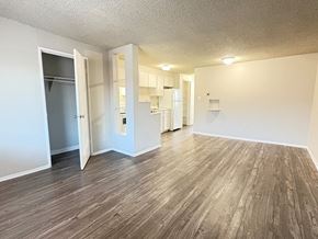 Denver apartment for rent - A room with a wooden floor and white walls.