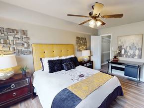 Little Rock apartment for rent - A bedroom with a bed, nightstands, and a ceiling fan.