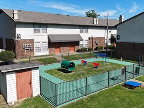 Little Rock apartment for rent - A playground area with a green fence and a red and blue slide.
